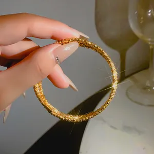 Vista dettagliata di un bracciale dorato multistrato con granuli metallici di lusso
