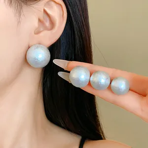 Macro detail of textured silver cotton pearl stud earrings showing unique surface and scale