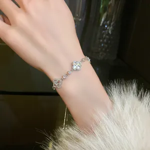 Close-up of a silver zircon flower bracelet featuring a mother of pearl clover and stones