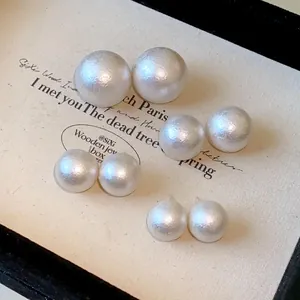 Detailed view of textured cotton pearl stud earrings in multiple sizes