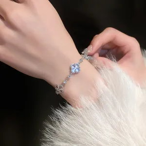 Detailed shot of a sparkling zircon flower bracelet on a wrist with white faux fur.