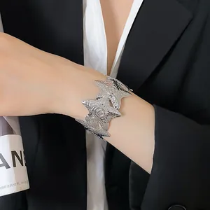 Close-up of a silver metallic wrinkled star cuff bracelet on a model's wrist for fashion