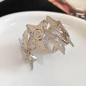 Detailed view of a silver starfish-shaped metal cuff bracelet with wrinkled texture