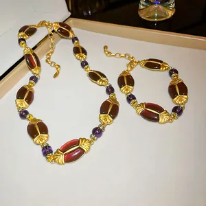 Detaillierte Nahaufnahme eines Vintage-Schmucksets mit dunklen Bernsteinperlen und Gold