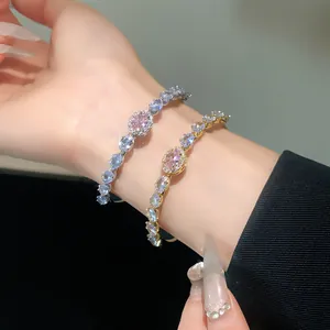 Close-up of elegant zircon bangles with pink oval center stones on a wrist
