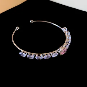 Close-up detail of silver open cuff bangle featuring oval pink and white cubic zirconia stones