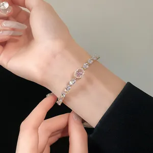 Detail view of a luxury zircon bracelet with a pink oval centerpiece on a wrist