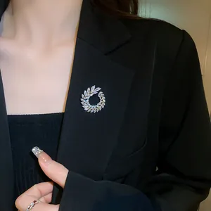 Elegant sparkling cubic zirconia wreath brooch shown pinned to a professional black blazer