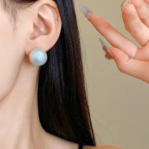 Detailed macro view showing the unique texture of a blueish cotton pearl stud earring worn on ear