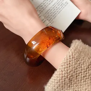 Detail view of a vintage amber irregular resin bangle with artistic swirl patterns