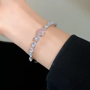 Close-up of a luxury silver-tone open bracelet with pink and clear oval zircons.