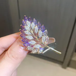 Elegant leaf-shaped brooch detailed with purple and white shimmering zircon crystals