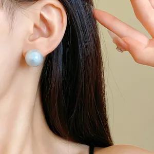 Detailed view of an elegant textured silver-white cotton pearl stud earring on model