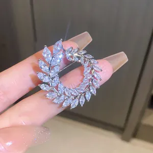 A detailed macro view of a sparkling zircon wreath brooch with premium silver plating