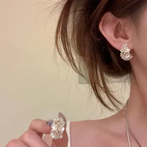 Elegant C-shaped earrings featuring delicate white pearl flowers on premium silver needles.