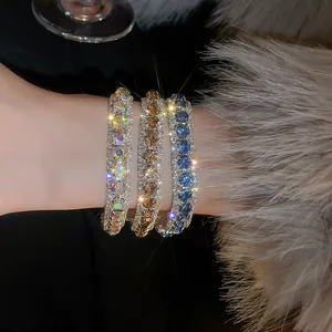Macro view of three sparkling crystal-encrusted bracelets on a stylish wrist