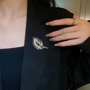 Elegant gold-plated wheat ear brooch with purple zircons pinned on a black blazer.