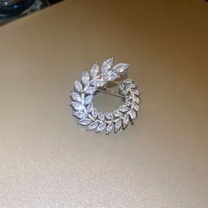 Close-up detail showing a sparkling zircon wreath brooch with elegant marquise-cut stones