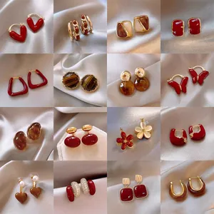 Vintage red and brown earring collection featuring heart and geometric patterns.