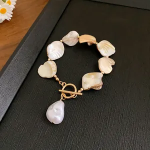Elegantes Armband mit unregelmäßigen Perlen, Gold-Knebelverschluss und Barock-Anhänger