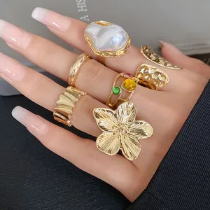 Close-up detail of stylish irregular geometric gold-tone open ring set with flower design