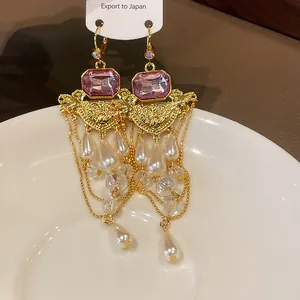 Détail de boucles d'oreilles style palais vintage avec perles et pierres mauves