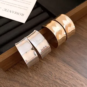 Close-up of elegant gold and silver hammered wide C-shaped hoop earrings on display