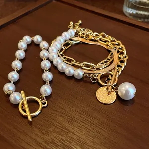 Gros plan d'un bracelet multicouche rétro en perles et chaîne dorée avec fermoir