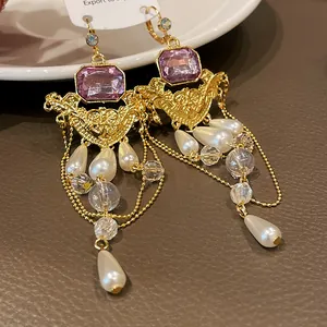 Détail de boucles d'oreilles style cour française vintage avec pierre mauve et perles