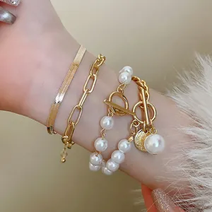Gros plan d'un ensemble de bracelets en or vintage avec perles et breloques.