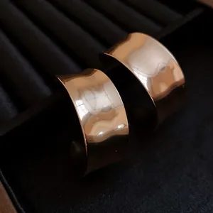 Macro detail of vintage gold C-shaped hoop earrings with glossy metallic finish.