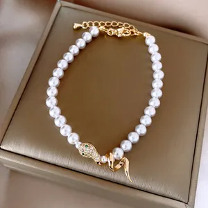 Detailed view of elegant pearl bracelet with crystal-encrusted snake head motif