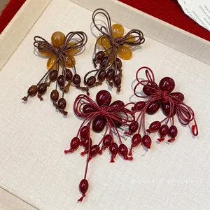 Eleganti orecchini a nappa con fiori e fiocchi in resina, nei colori rosso e ambra