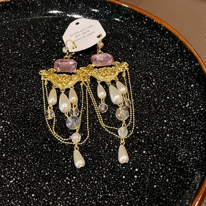 Détail de boucles d'oreilles vintage françaises avec perles, cristaux et pierres roses.