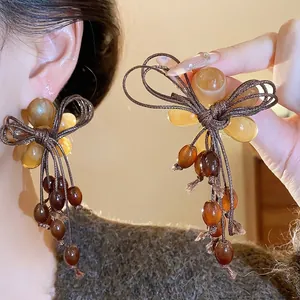 Eleganti orecchini a nappa con perline in resina ambrata ideali per gli stili autunnali.