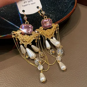 Détail de boucles d'oreilles vintage style cour française avec perles et gemmes