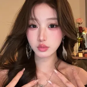Asiatisches Model mit eleganten silbernen hohl geschnitzten Ohrringen in warmem Ambiente