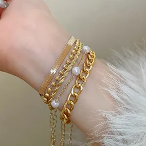 Détail d'un ensemble de 5 bracelets vintage dorés avec perles et chaîne serpent