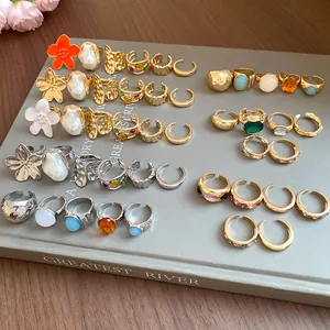 Detailed macro view of assorted gold and silver irregular open rings with pearls and gems