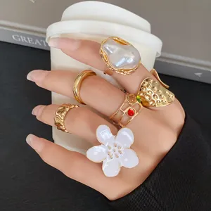 Close-up detail of a 5-piece set of trendy gold-finish irregular open rings on hand