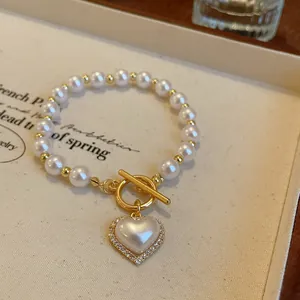 Vue détaillée d'un élégant bracelet en perles avec fermoir OT doré et pendentif en cœur