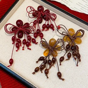 Orecchini a fiore in resina con fiocco e nappe in rosso e ambra realizzati a mano