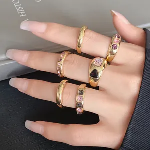 Close-up of gold geometric irregular open ring set with colorful crystals on fingers