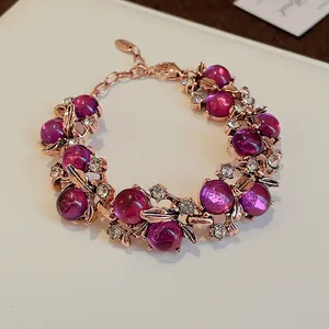 Dettaglio di bracciale vintage in oro rosa con perle viola e accenti di foglie