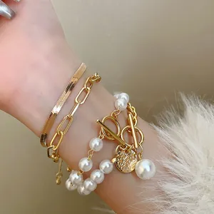 Gros plan détaillé d'un élégant bracelet multicouche chaîne serpent dorée et perles avec fermoir OT