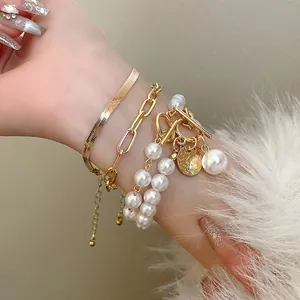 Vue détaillée d'un ensemble de bracelets dorés multicouches avec perles et chaîne serpent