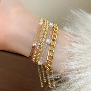 Vue détaillée de bracelets dorés superposés avec perles et chaîne de style serpent