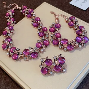 Dettaglio ravvicinato di un set di gioielli vintage con perle viola e motivi a foglia