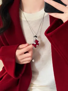Close-up detail of a red flocked rocking horse pendant necklace with crystal accents