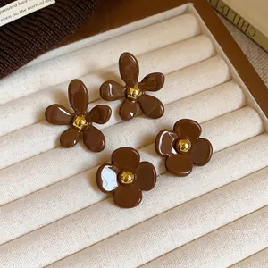 Boucles d'oreilles fleur marron Maillard rétro dans un plateau à bijoux crème élégant
